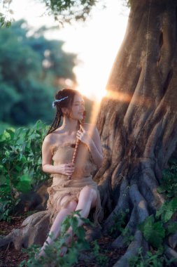 Nostaljik tema, ağacın altında flüt çalan kız.