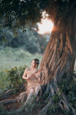 Nostaljik tema, ağacın altında flüt çalan kız.