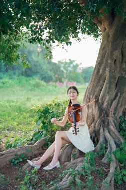 Genç kız ormanda keman çaldı.