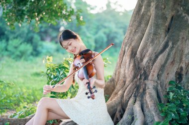 Genç kız ormanda keman çaldı.