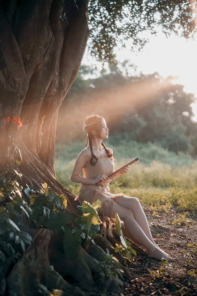 stock image Nostalgic theme, girl playing flute under tree