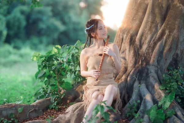 Stock image nostalgic theme, girl playing flute under tree