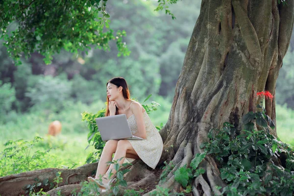 那女孩在树林里用笔记本电脑 — 图库照片