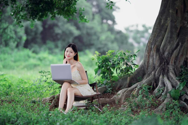 少女は森の中でノートパソコンを使う — ストック写真