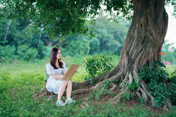 女孩正在大树下画画 — 图库照片