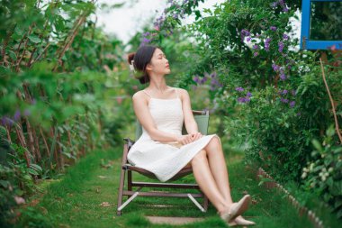 Kız bahçede kitap okuyor.