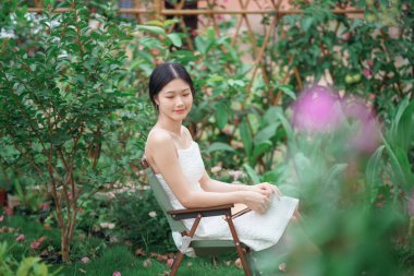 Kız bahçede kitap okuyor.