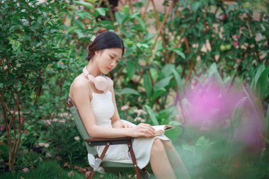 Kız bahçede kitap okuyor.