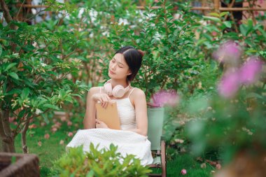 Kız bahçede kitap okuyor.