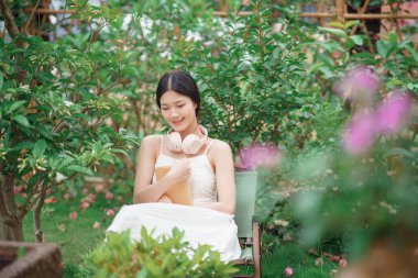 Kız bahçede kitap okuyor.