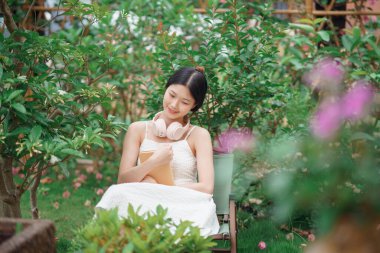 Kız bahçede kitap okuyor.