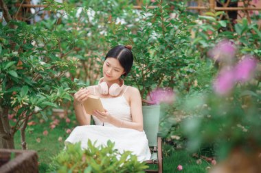 Kız bahçede kitap okuyor.