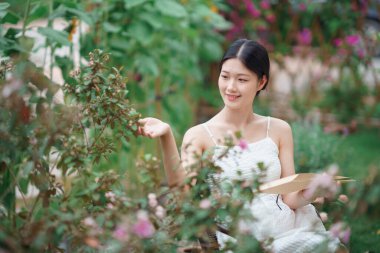 Kız bahçede kitap okuyor.