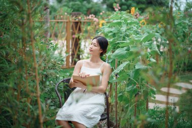 Kız bahçede kitap okuyor.