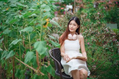 Kız bahçede kitap okuyor.