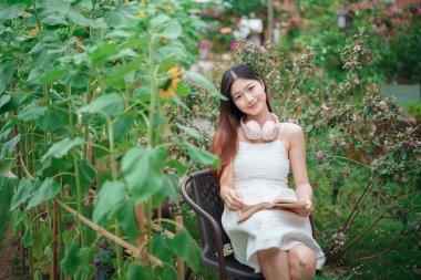 Kız bahçede kitap okuyor.