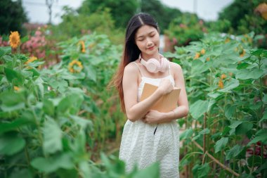 Kız bahçede kitap okuyor.