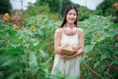 Kız bahçede kitap okuyor.