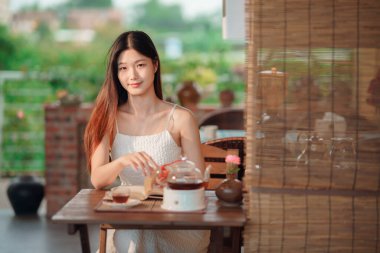 Kız bahçede kitap okuyor.