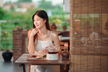 Kız bahçede kitap okuyor.