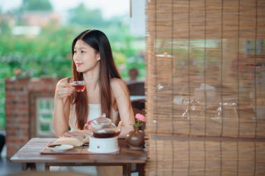 Kız bahçede kitap okuyor.