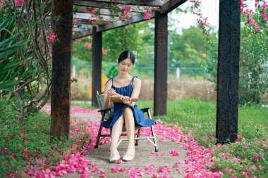 Genç kızlar bahçede kitap okurlar.