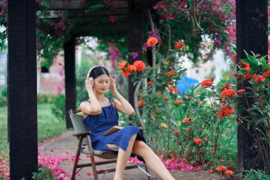 Kız bahçede kitap okuyor.