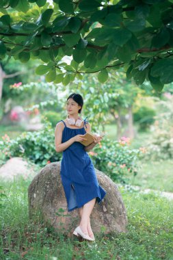 Kız bahçede kitap okuyor.