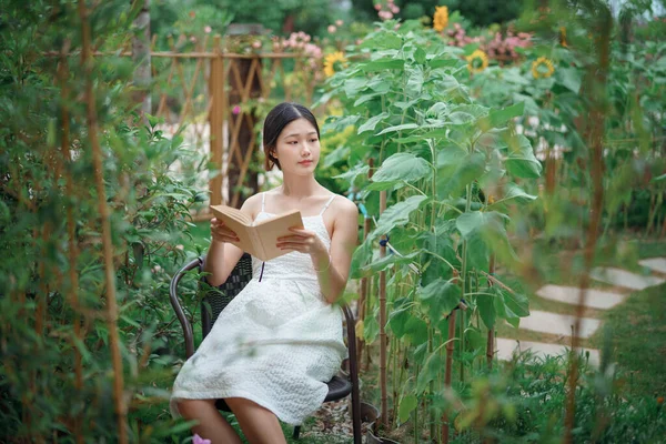 少女は庭で読んでいる — ストック写真