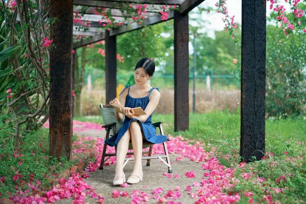 若い女の子は庭で本を読む — ストック写真