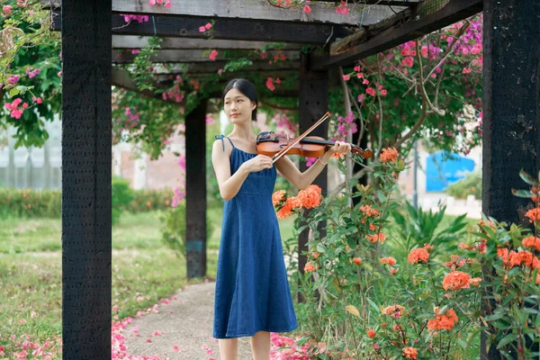 少女は庭でバイオリンを弾いている — ストック写真