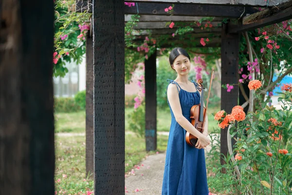 那女孩正在花园里拉小提琴 — 图库照片