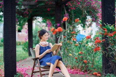 Kız bahçede kitap okuyor.