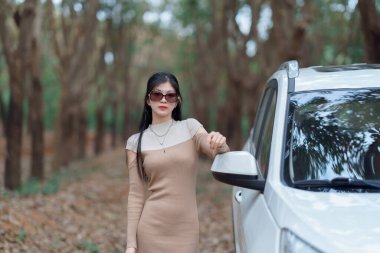 Şoför kız arabanın yanında.