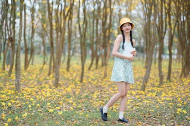 Kız ormanda kitap okuyor.