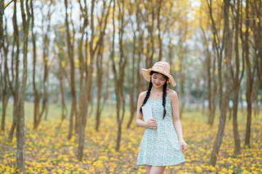 Kız ormanda kitap okuyor.