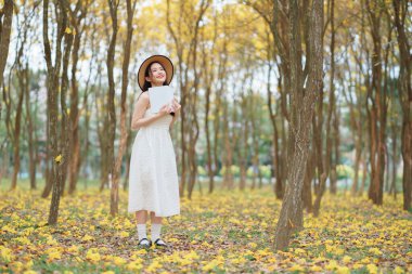 Kız ormanda kitap okuyor.