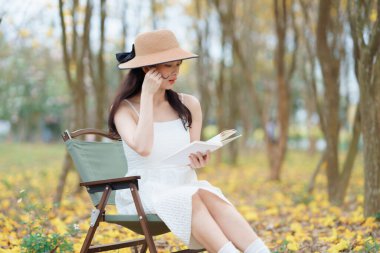 Kız ormanda kitap okuyor.