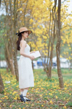 Kız ormanda kitap okuyor.