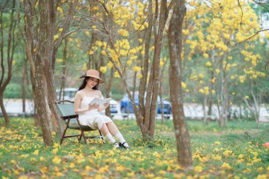 Kız ormanda kitap okuyor.
