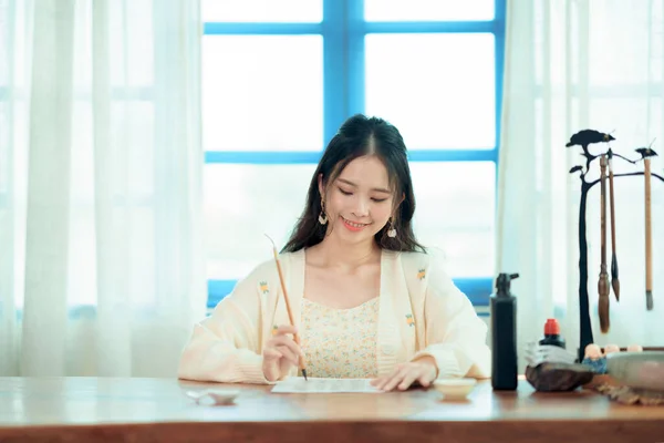 Chinese girls are writing Chinese characters with brush strokes