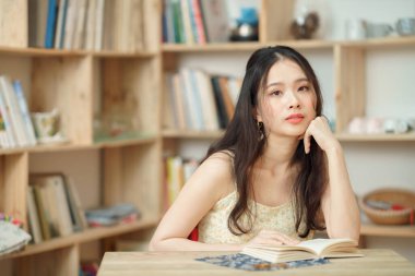 Kız çalışma odasında okuyor.