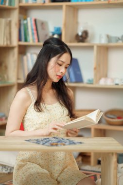 Kız çalışma odasında okuyor.