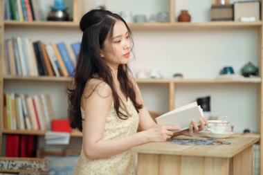 Kız çalışma odasında okuyor.