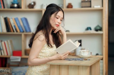 Kız çalışma odasında okuyor.