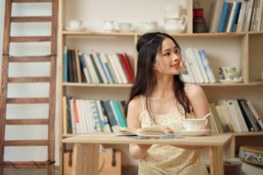 Kız çalışma odasında okuyor.