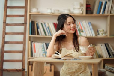 Kız çalışma odasında okuyor.