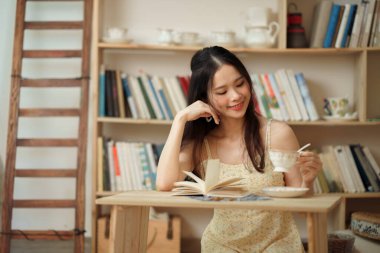 Kız çalışma odasında okuyor.