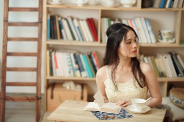 Kız çalışma odasında okuyor.