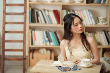 Kız çalışma odasında okuyor.